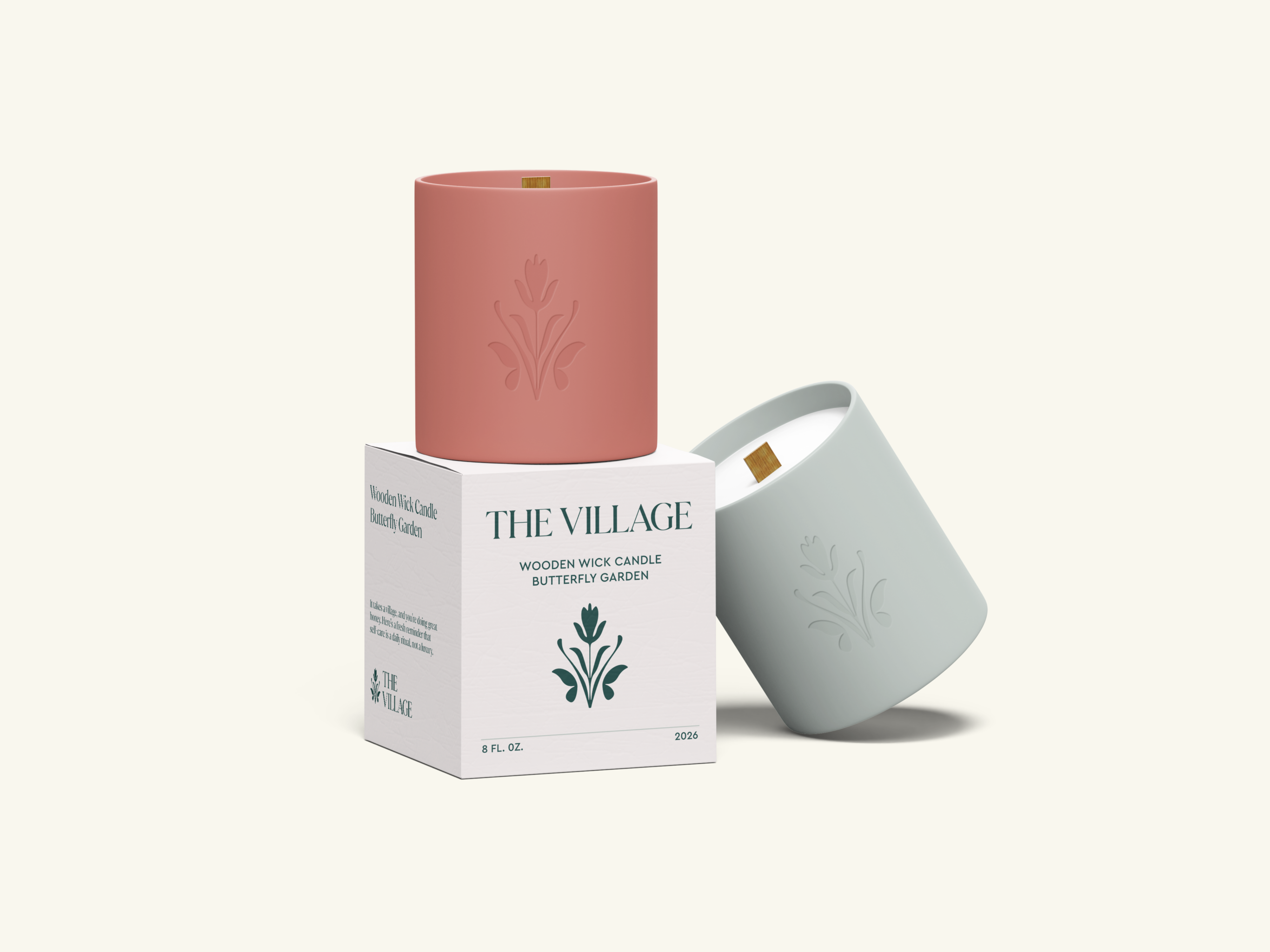 The Village wooden wick candle in pink and gray ceramic vessels with butterfly garden branding and white box packaging.